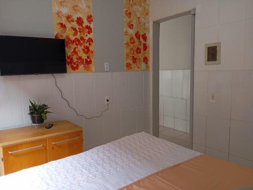 a bedroom with a bed and a flat screen tv at Apto 4 Bom Preco in Riacho Fundo