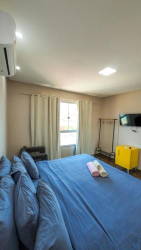 a bedroom with a large blue bed with two pillows at Pousada Casa Flor-Aurora -TO in Manhã