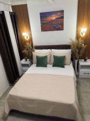 a bedroom with a large white bed with green pillows at Mayfair Apartment Ksamil in Ksamil
