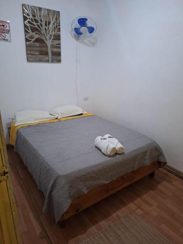 a bedroom with a bed with two towels on it at Hotel Cortez Azul in Alajuela City