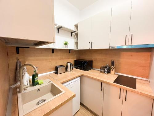 a kitchen with white cabinets and a sink at Fly Residence 2 in Arad
