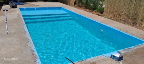 a swimming pool with blue water in a yard at Cabañas Balcón del Famatina in Chilecito