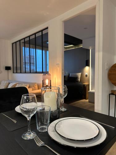 - une table avec une assiette et des verres à vin dans l'établissement Suite Miraval, à La Baule