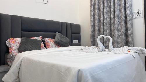 two swans are sitting on a white bed at Millennium Suites in Orchha