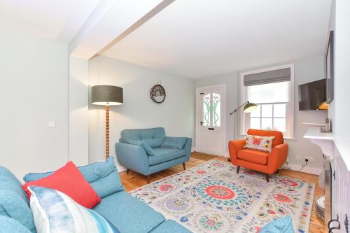 a living room with a blue couch and two chairs at Dove Cottage is a Central, Riverside, Charming Victorian Cottage in Arundel
