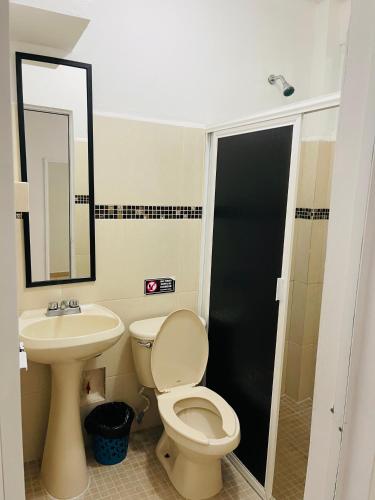 a bathroom with a toilet and a sink and a mirror at CONDO Marena 2 in Playa del Carmen