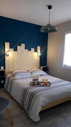 une chambre avec un grand lit avec un mur bleu dans l'établissement Maison les pieds dans le sable 350m de la mer vélos, à Bretignolles-sur-Mer