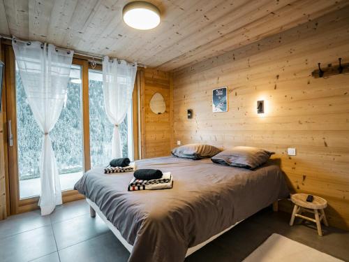 a bedroom with a bed in a wooden cabin at Chalet 3 Pièces, 6 Pers., Exposition Sud avec Terrasse et Parking Privatif - FR-1-676-192 in Châtel