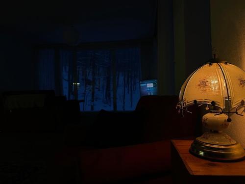 a lamp sitting on a table in a dark room at Black Fox in Ferizaj