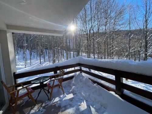 a balcony with a view of a snow covered forest at Black Fox in Ferizaj