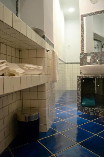 a bathroom with a blue tiled floor and a sink at Dimora Tafuri in Salerno