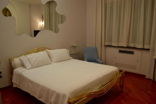 サレルノにあるDimora Tafuriのベッドルーム(白いベッド1台、青い椅子付)