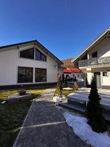 a house with a driveway in front of it at Vila Casa Din Vale - Valiug in Văliug