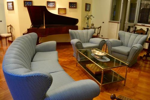 a living room with blue chairs and a piano at Dimora Tafuri in Salerno