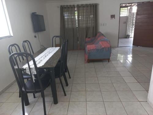 a dining room with a table and chairs and a bed at Linhares hospedagem in João Pessoa