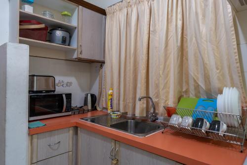 a kitchen with a sink and a microwave at Jemhaus Studio Sunset Seaview [Netflix & Cuckoo] in Lumut