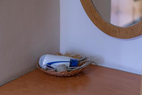 a basket of items sitting on a wooden floor next to a mirror at Jemhaus Studio Sunset Seaview [Netflix & Cuckoo] in Lumut