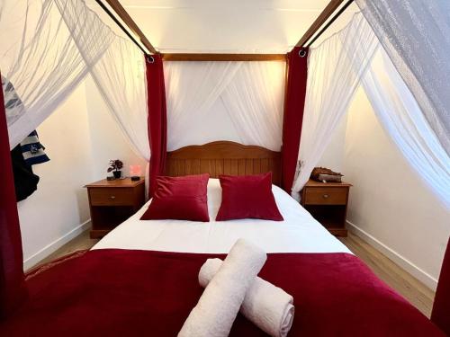 a bedroom with a red and white bed with red pillows at Le Refuge mysterieux d'Harry proche Gare Toulouse in Toulouse