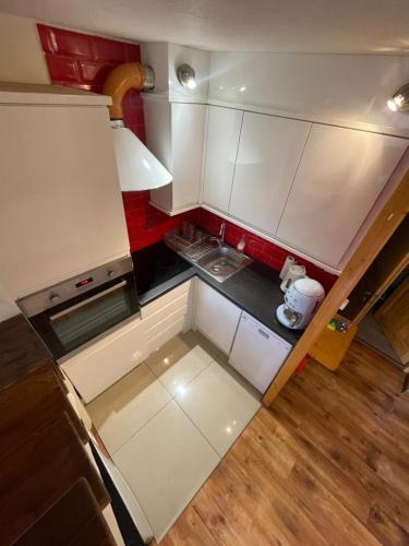 - une vue sur le dessus d'une petite cuisine avec des placards blancs dans l'établissement L'ECLIPSE, à Courchevel