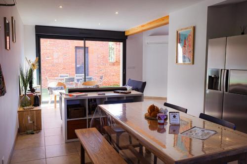 une cuisine avec une table et une salle à manger dans l'établissement Gite de caractère à Beaupuy, à Beaupuy