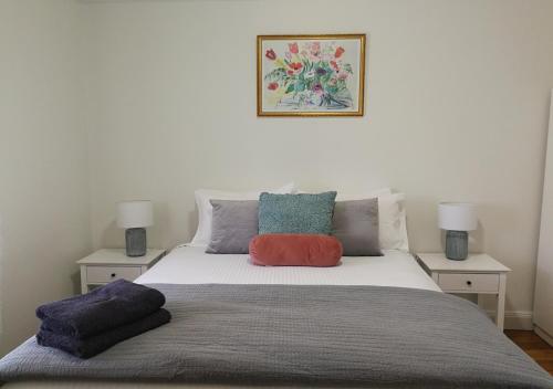 a bed with two pillows on top of it at Merala a cosy cottage with easy stroll to CBD in Mudgee