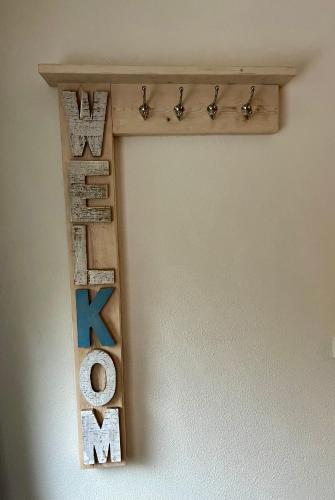 a shelf made out of wood with the word love at B&B Vloedlijn Texel in Den Burg