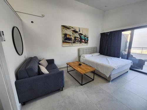 a bedroom with a bed and a couch and a table at דופלקס כנרת in Tiberias