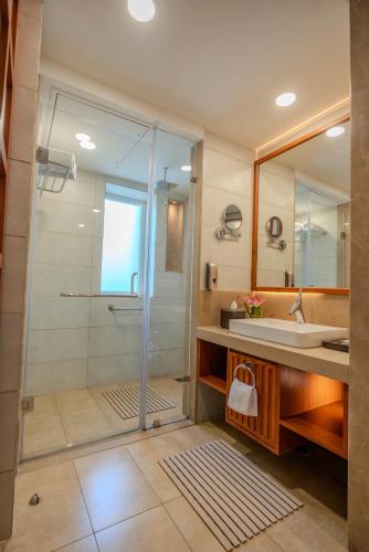 a bathroom with a glass shower and a sink at Welcomhotel By ITC Hotels, Jim Corbett in Marchula