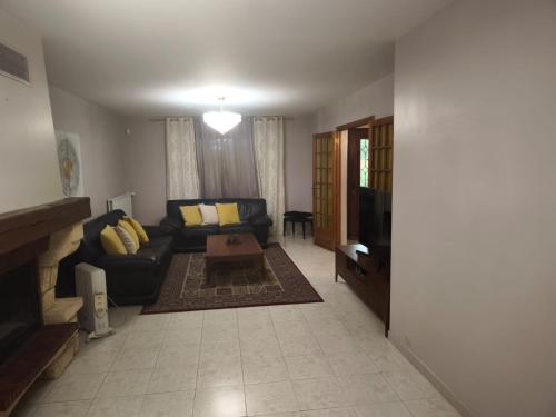 een woonkamer met een bank en een tv bij MAISON Aéroport CDG Parc des expos Villepinte Bourget Astérix in Goussainville