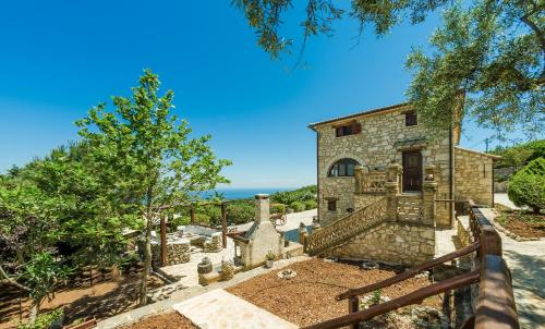 uma vista exterior de uma casa de pedra com uma cerca em Villa Poseidon Residence em Skinária