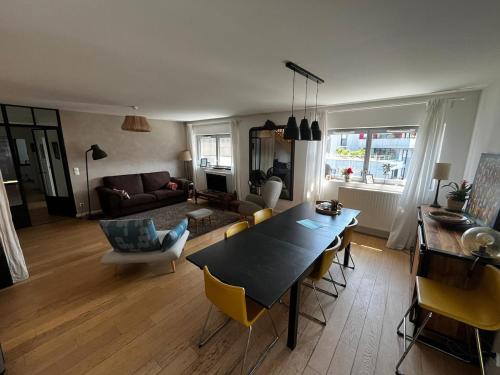 un salon avec une table, des chaises et un canapé dans l'établissement Superb 100m with Rooftop Terrace Near Paris, à Ivry-sur-Seine