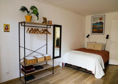 een slaapkamer met een bed en een plank met schoenen bij Le Petit Kandinsky in Le Kremlin-Bicêtre