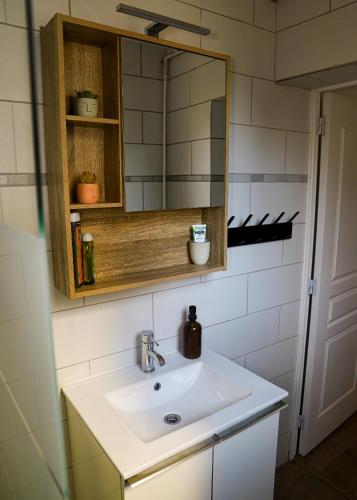 une salle de bain avec un lavabo et un miroir dans l'établissement Le Petit Kandinsky, au Kremlin-Bicêtre