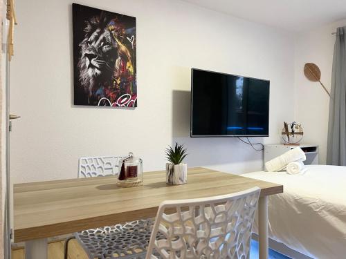 d'une salle à manger avec une table et une télévision murale. dans l'établissement Le nid du busca proche métro, à Toulouse