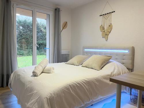 un lit blanc dans une chambre avec une fenêtre dans l'établissement Le nid du busca proche métro, à Toulouse