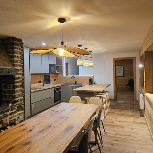 une cuisine avec une grande table et des chaises en bois dans l'établissement Grand appartement 200m2 au pied des pistes, à La Giettaz