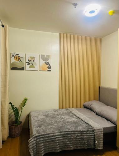 a bedroom with a bed and a plant in it at Wanderer's Home at Seawind Condo near Davao Airport in Davao City