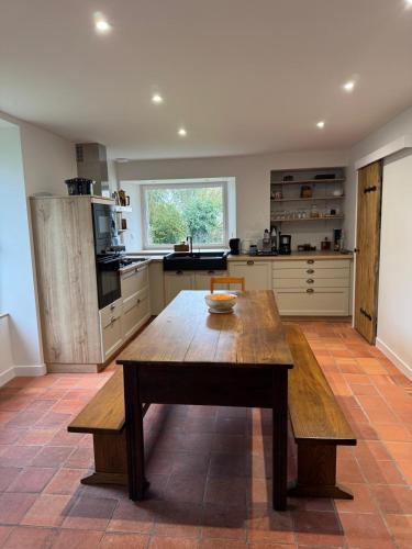 une cuisine avec une table en bois au milieu dans l'établissement Les Bâtisses de 1872, à Ménéac