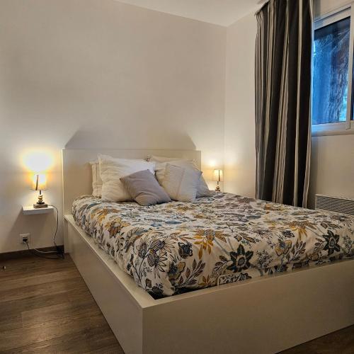 Ce lit se trouve dans une chambre dotée de 2 lampes et d'une fenêtre. dans l'établissement Baie du Mont-Saint-Michel et Côte Normande - Les Secrets du Rivage, à Saint-Pair-sur-Mer