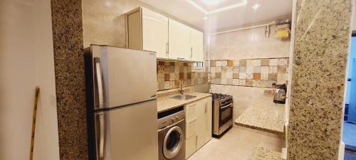 uma grande cozinha com um frigorífico e um lavatório em ARENA apartment sea view hi Lox em Alexandria