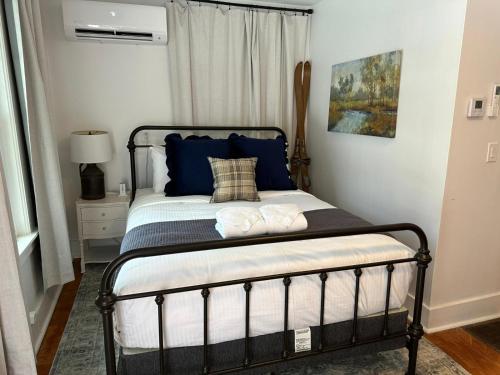 a bedroom with a bed with blue pillows at The Aurora Inn & Cottages in Bartlett
