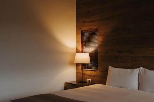 a bedroom with a bed with a lamp and a window at Yanyu Yuchi BY REINDEER in Yuchi