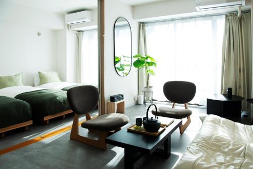une chambre avec un lit et deux chaises et un miroir dans l'établissement Zen apartment in central Tokyo, à Tokyo