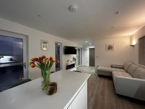 a living room with a vase of flowers on a counter at Lowern, Luxury Lodge with Hot Tub and Games Room in Menai Bridge
