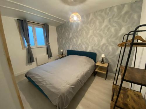 a small bedroom with a bed and a window at Appartement in Lanrodec