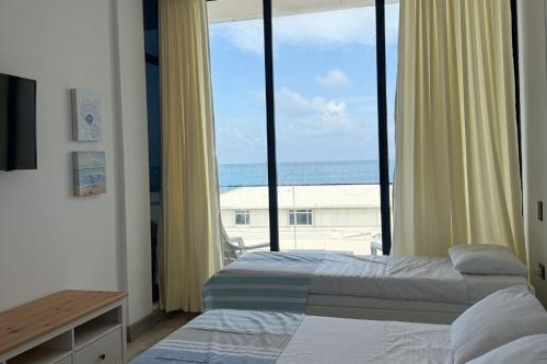 a bedroom with two beds and a view of the ocean at Sensacional Apto NUEVO con Vista al Mar in Gustavo Rojas Pinilla International