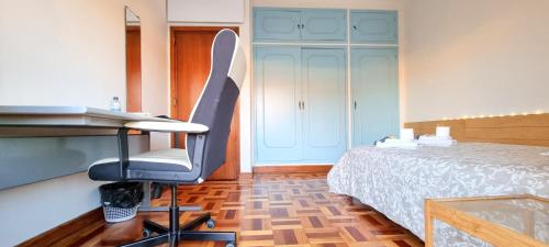 a room with a bed and a desk and a chair at CQ Coimbra in Coimbra