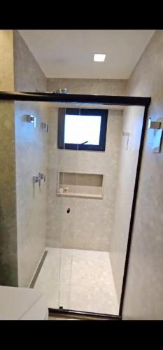 a shower stall with a window in a bathroom at Apto Salinas Premium - 2 quartos - 1 suíte in Salinópolis