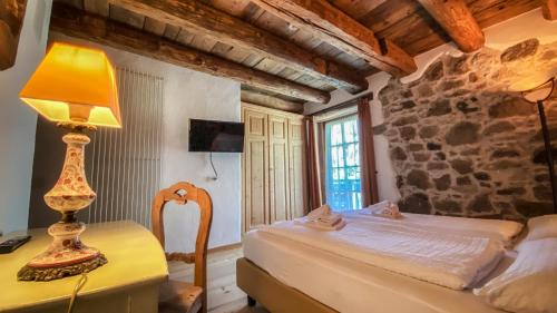 a bedroom with a bed and a lamp on a desk at Maso Franceschella in Carano
