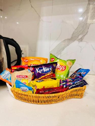 a basket of chips and other snacks on a counter at Oasis Suits DHA in Lahore
